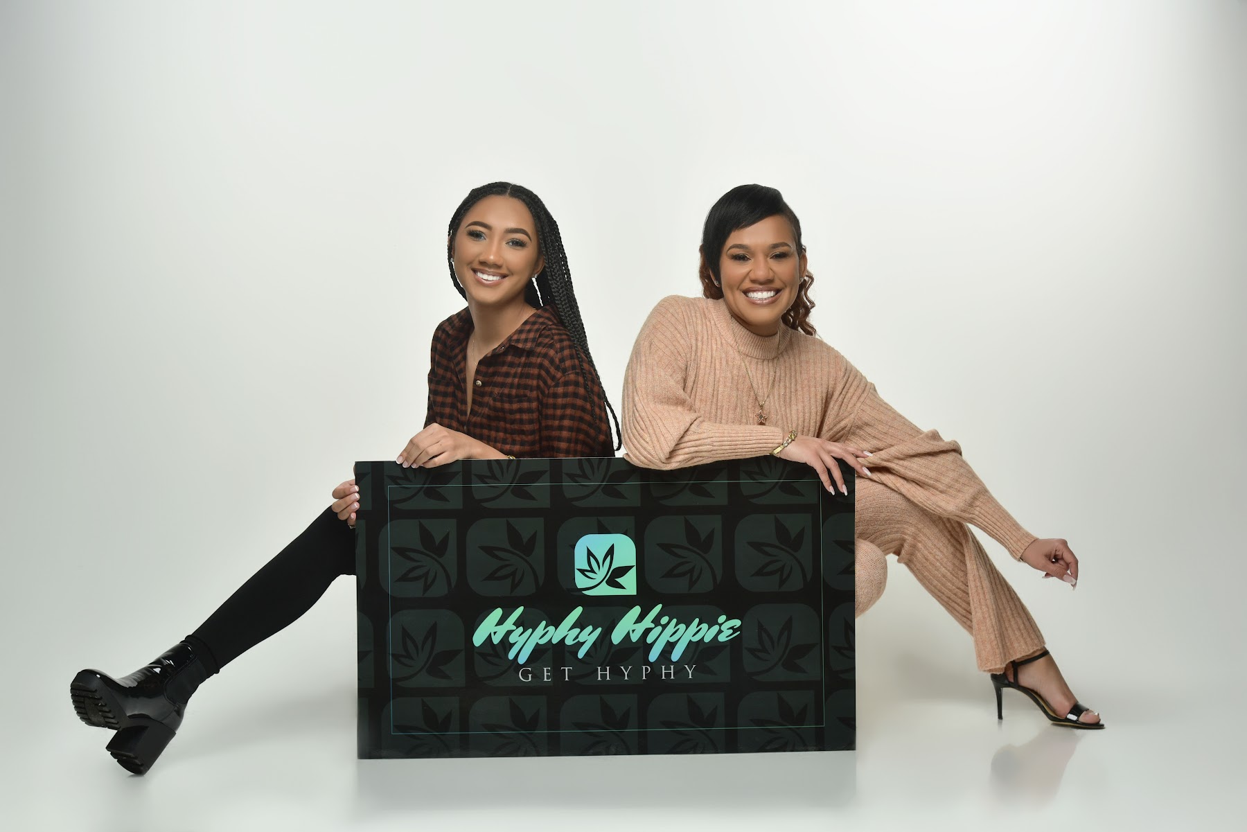 The owners celebrating behind the Hyphy Hippie sign