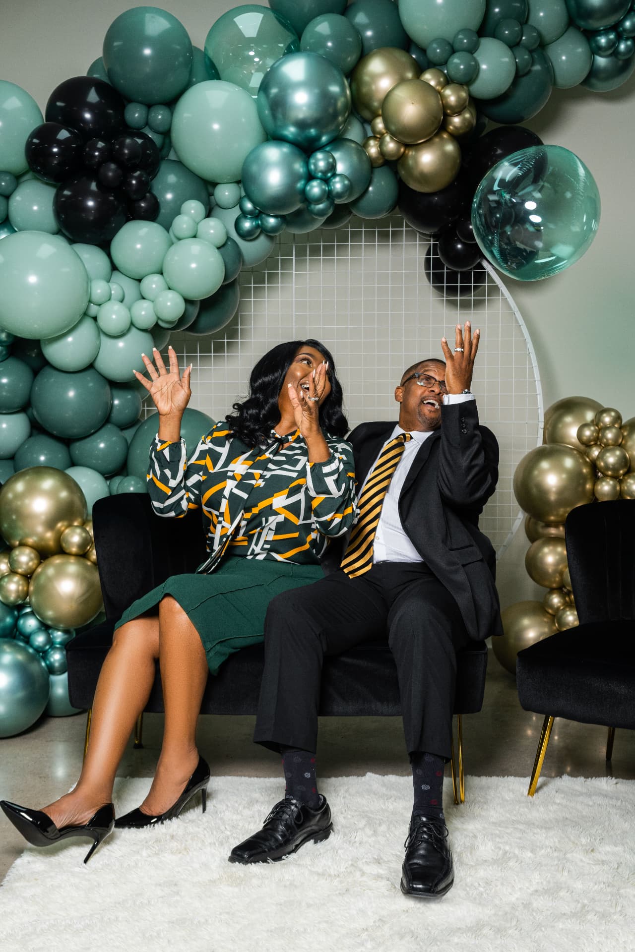 Two people sharing a joyful moment beneath the balloon decor