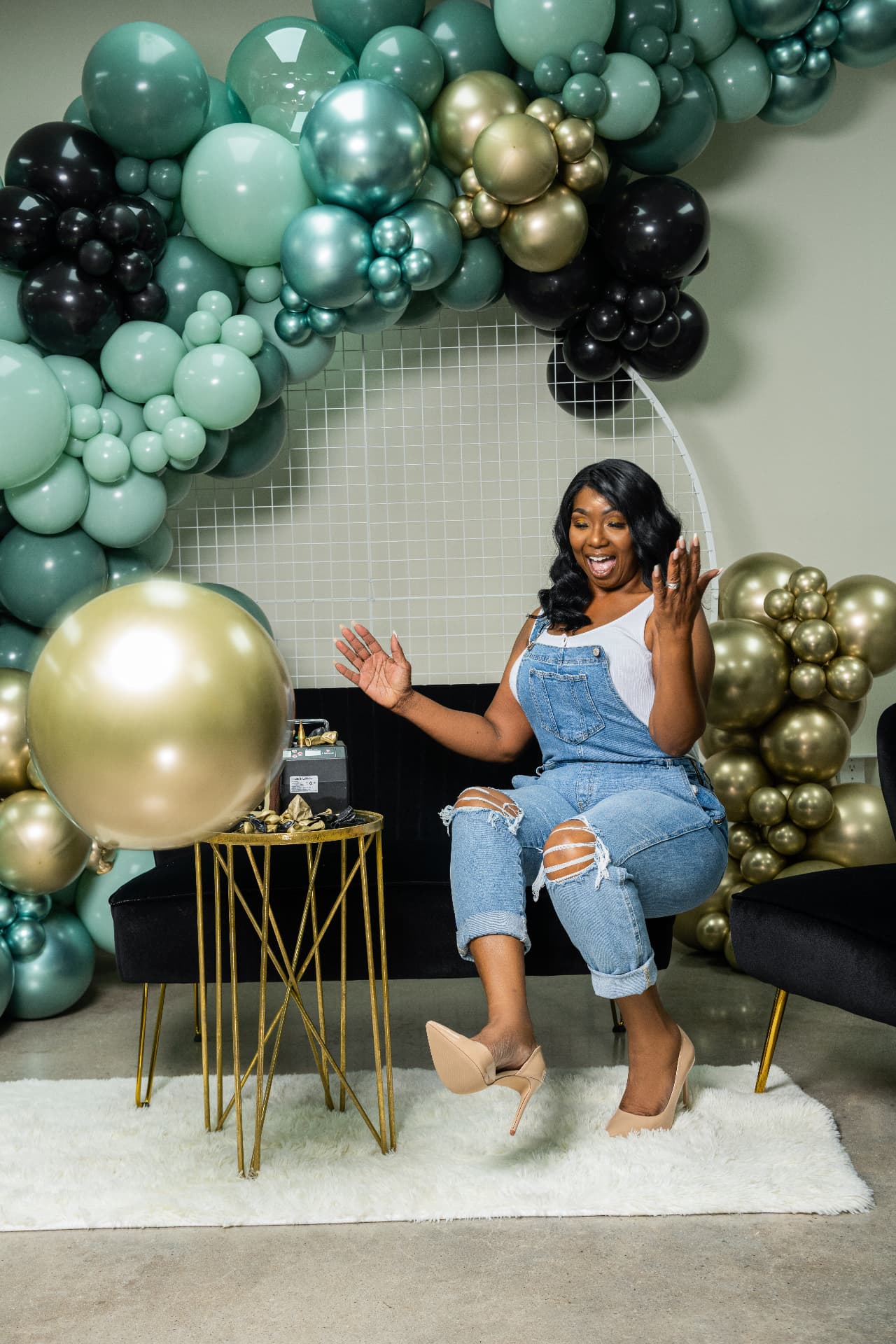 Relaxed brand portrait beside a gold balloon